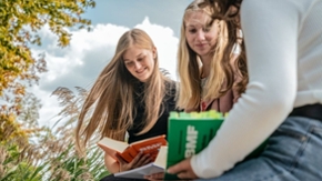 Drei Mädchen sitzen draußen und lesen Steuergesetze. (Quelle: Staatskanzlei) Drei Mädchen sitzen draußen und lesen Steuergesetze.