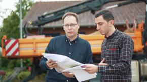 Zwei Männer studieren Unterlagen (Quelle: Land SH) Zwei Männer studieren Unterlagen